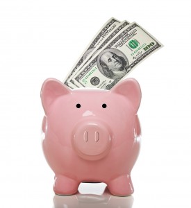 Pink piggy bank with hundred dollar bills